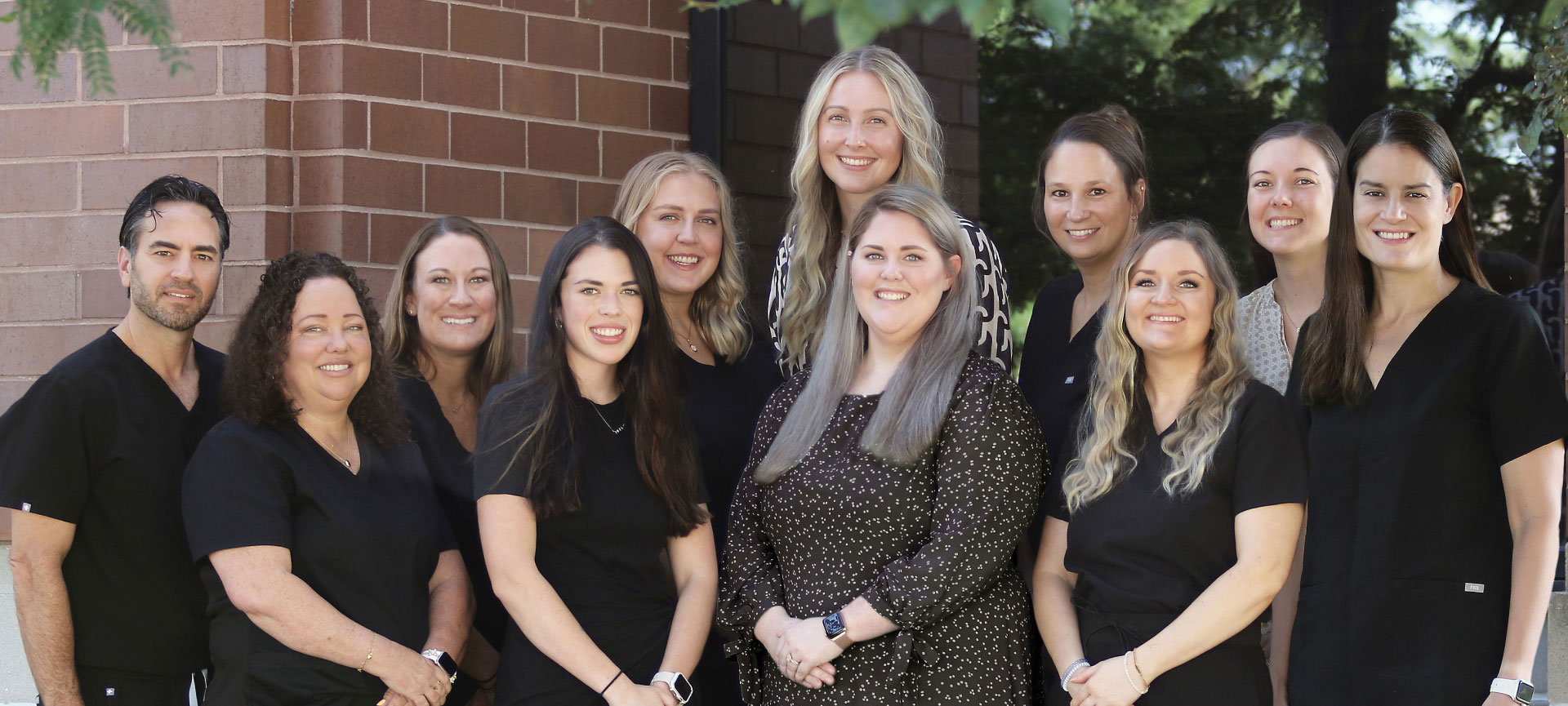 PDP Chesterfield dental team posing for picture outside in front of brick building